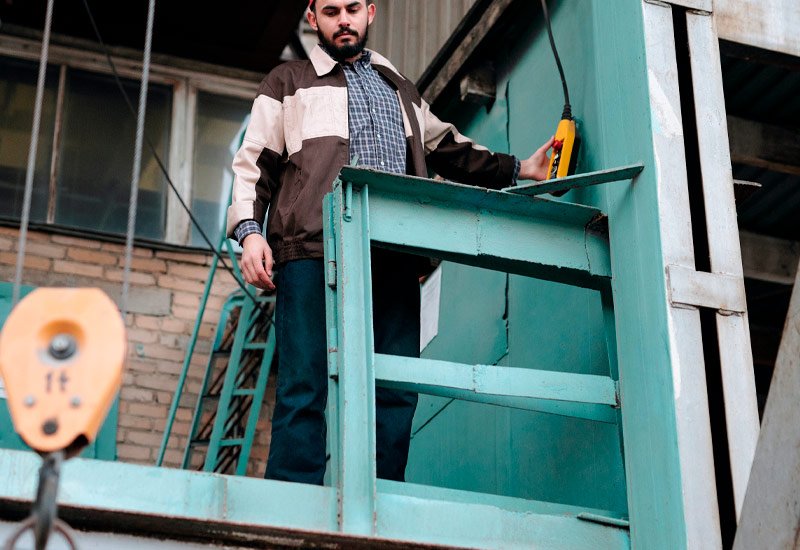 Alquilamos grúa montamuebles en Santander Hombre activando grúa montamuebles en Santander